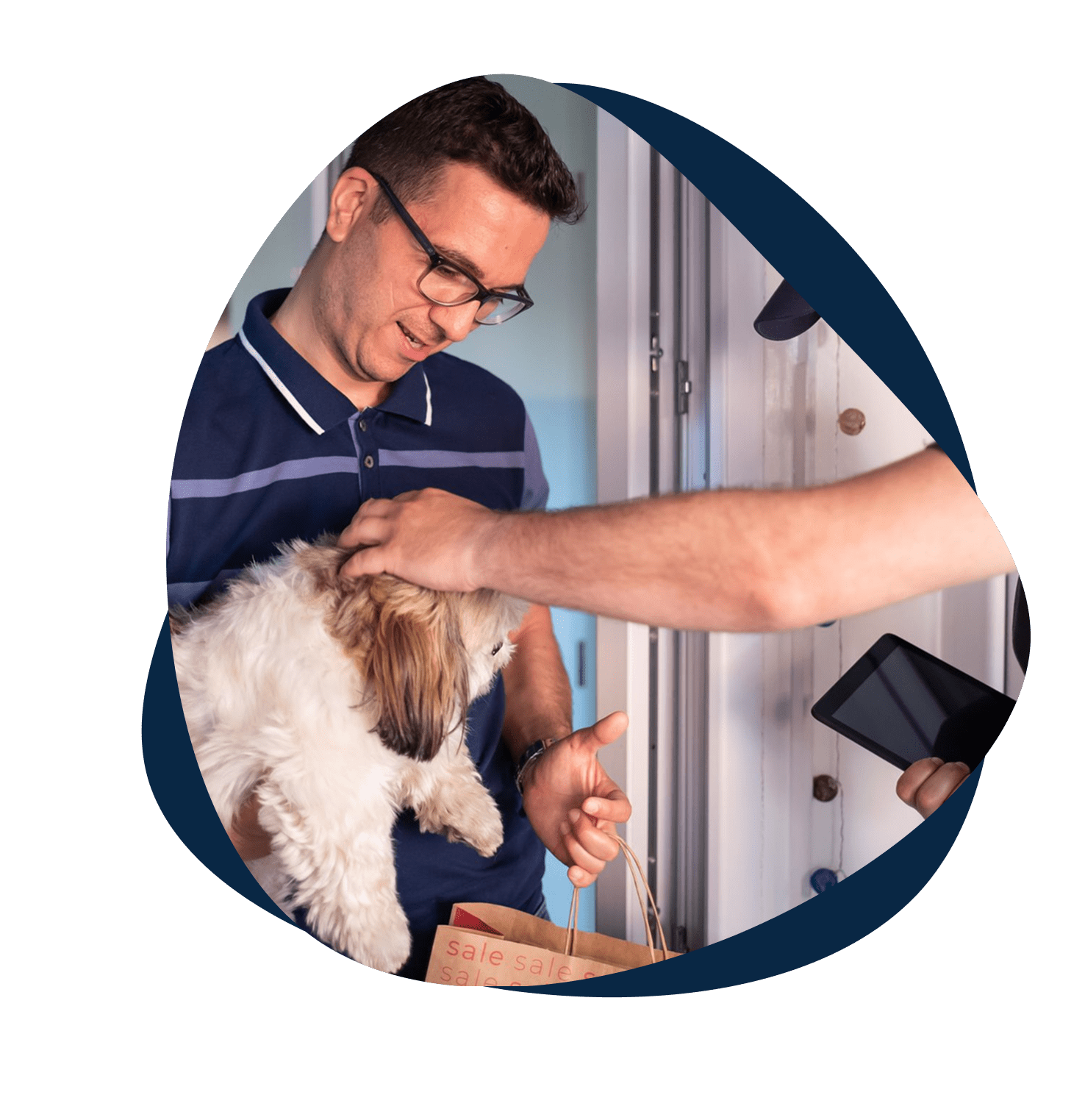 Man holding dog, interacting at doorstep.